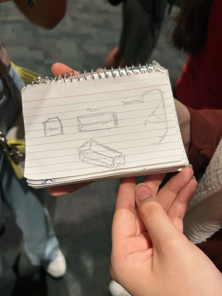 A designer showing a sketch of a possible robot.